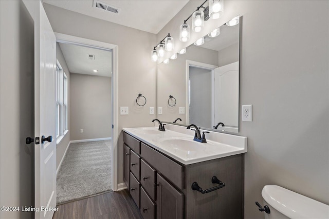 bathroom with hardwood / wood-style floors, toilet, and vanity