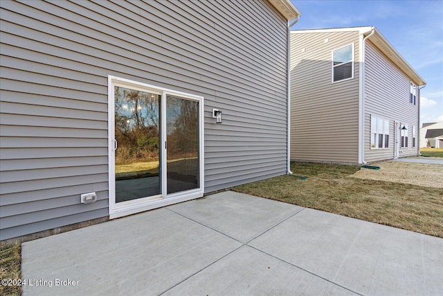 view of side of property with a patio area and a yard