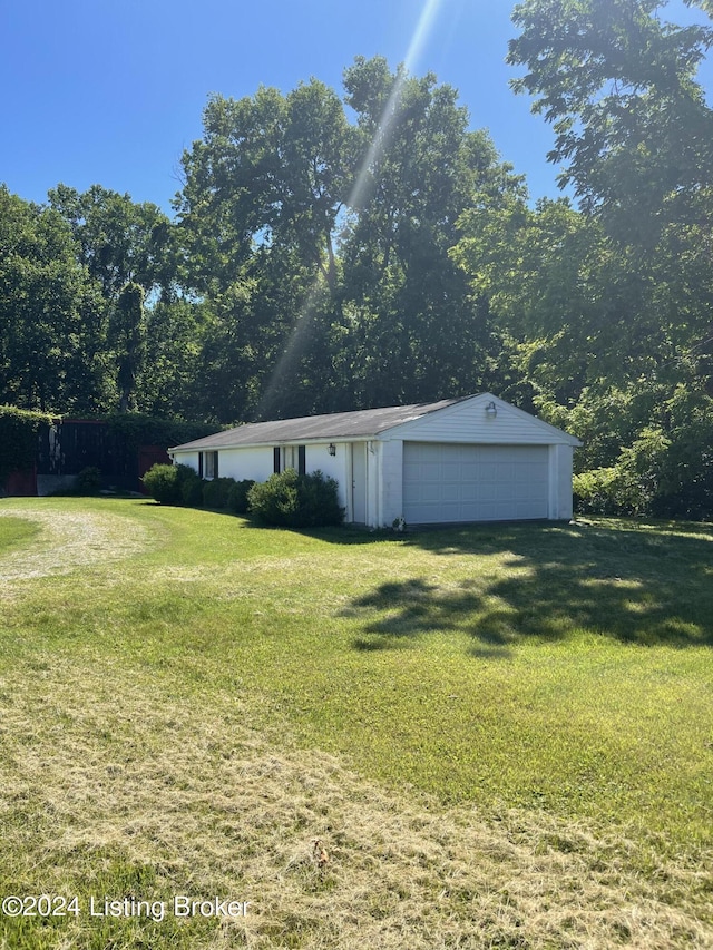 view of front of home with a garage, an outbuilding, and a front yard