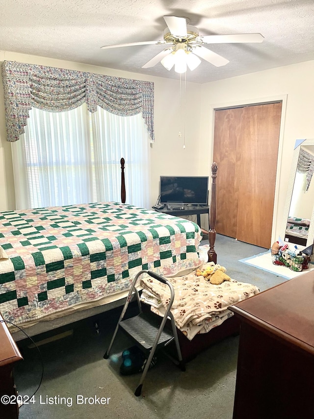 bedroom with a textured ceiling, carpet floors, a closet, and ceiling fan