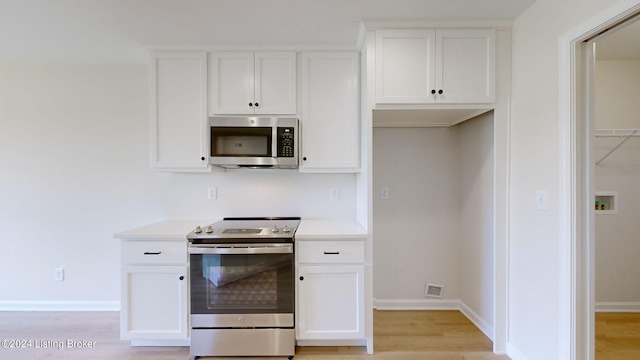 kitchen with white cabinetry, light wood-type flooring, and appliances with stainless steel finishes