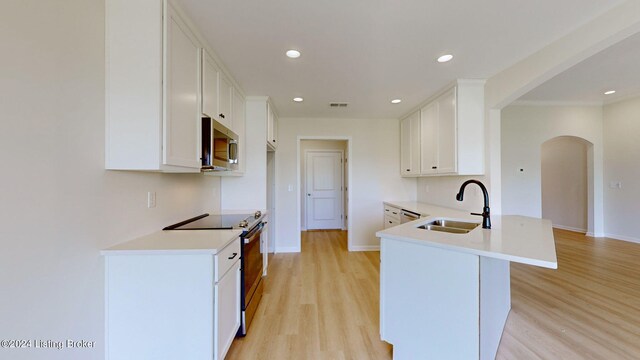 kitchen featuring white cabinets, sink, stainless steel appliances, and light hardwood / wood-style flooring