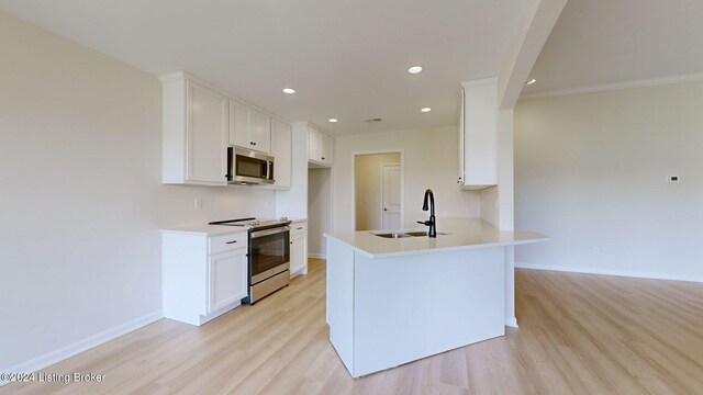 kitchen featuring sink, white cabinetry, stainless steel appliances, and light hardwood / wood-style flooring