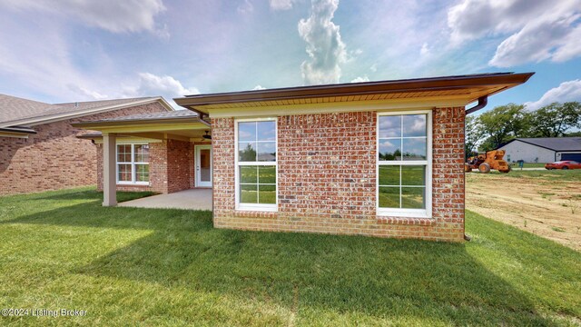 rear view of property with a lawn and a patio area