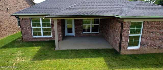 back of property featuring a patio area and a yard