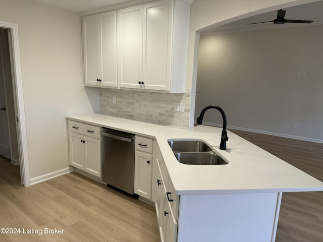 kitchen with dishwasher, sink, kitchen peninsula, white cabinets, and light wood-type flooring