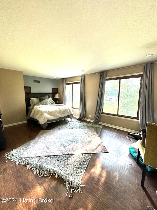 bedroom featuring dark hardwood / wood-style flooring and a textured ceiling