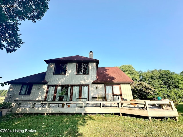 rear view of property featuring a wooden deck and a yard