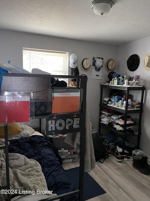 bedroom with wood-type flooring and a textured ceiling