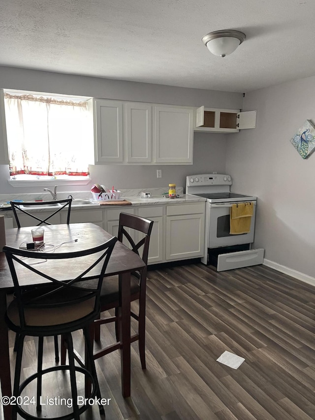 kitchen featuring a textured ceiling, electric range, white cabinets, and dark hardwood / wood-style floors