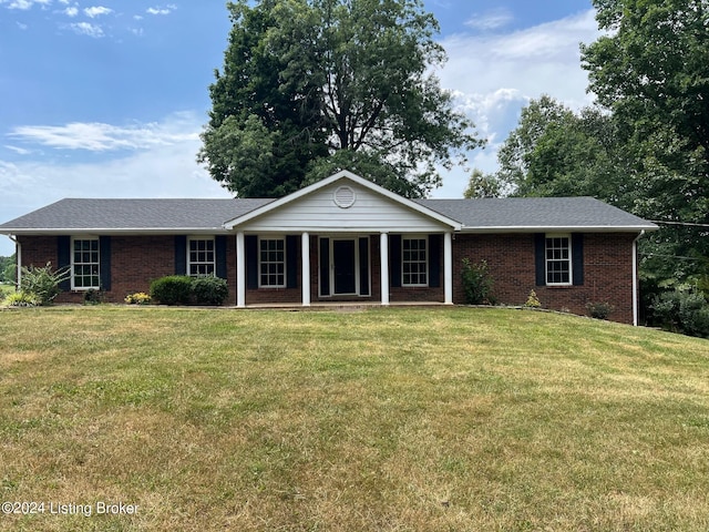 ranch-style house with a shingled roof, a front yard, and brick siding