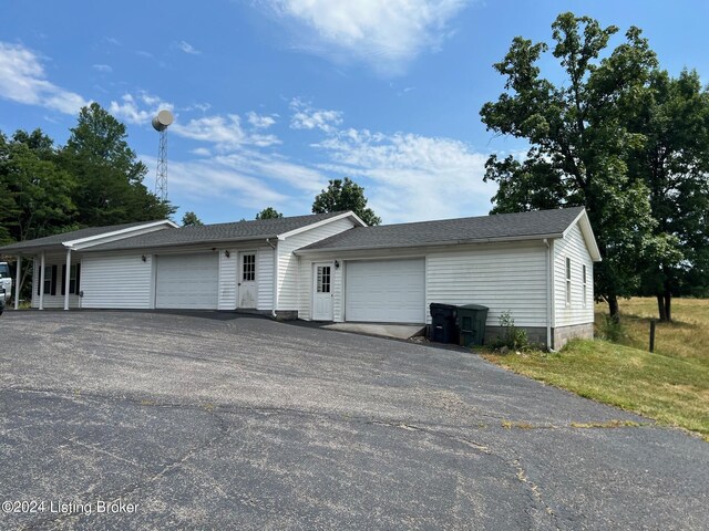 ranch-style house with an attached garage and aphalt driveway