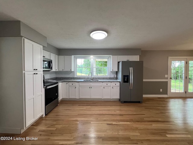 kitchen with a healthy amount of sunlight, white cabinets, and stainless steel appliances