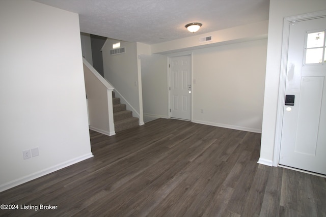 entrance foyer featuring dark hardwood / wood-style floors and a textured ceiling