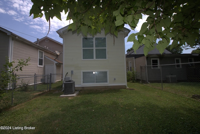 rear view of property featuring central AC unit and a yard