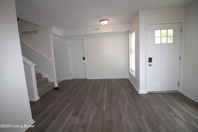 foyer featuring a textured ceiling and dark hardwood / wood-style floors