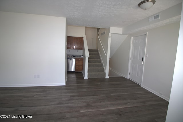 unfurnished living room featuring dark hardwood / wood-style floors and a textured ceiling