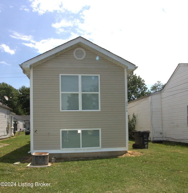 rear view of property featuring a yard and central AC unit