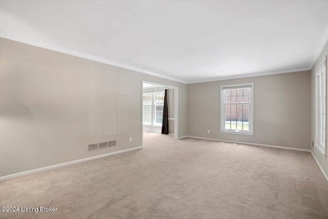 unfurnished room with a wealth of natural light, crown molding, and light carpet