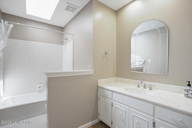 bathroom with vanity, shower / bathtub combination with curtain, and a skylight