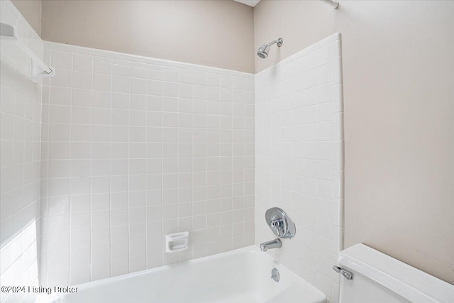 bathroom with tiled shower / bath combo and toilet