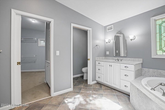 bathroom with vanity, tile patterned flooring, tiled bath, toilet, and lofted ceiling