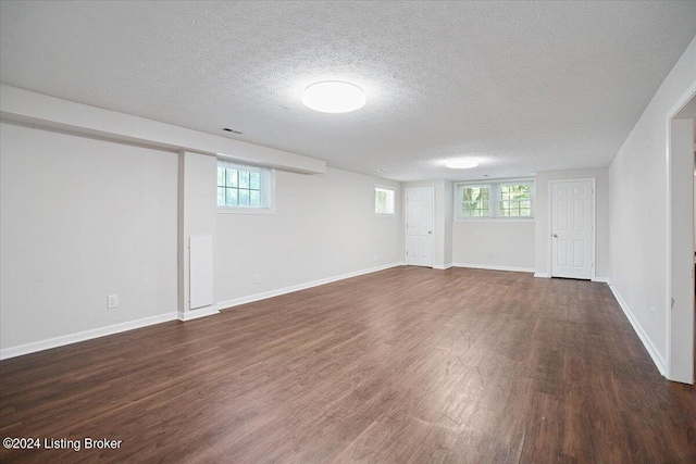 basement featuring dark hardwood / wood-style floors and a textured ceiling