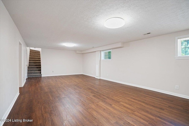 basement featuring dark wood-type flooring and a textured ceiling