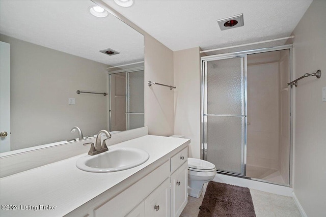 bathroom featuring walk in shower, vanity, a textured ceiling, and toilet