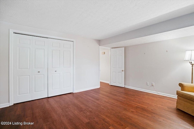 unfurnished bedroom featuring wood-type flooring, a textured ceiling, and a closet