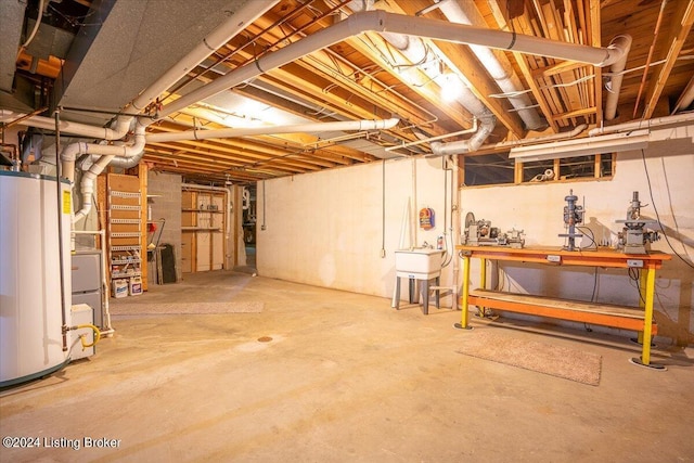 basement featuring a workshop area, water heater, and sink