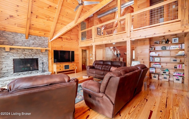 living room with high vaulted ceiling, a fireplace, light hardwood / wood-style floors, wooden ceiling, and beamed ceiling