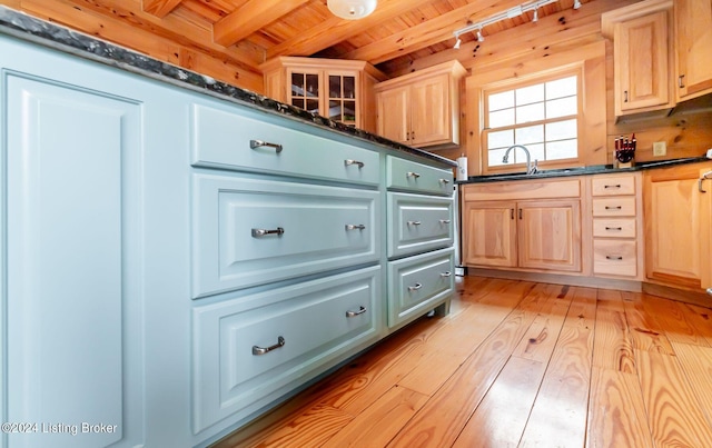 kitchen with wood walls, wood ceiling, light brown cabinets, beam ceiling, and light hardwood / wood-style flooring