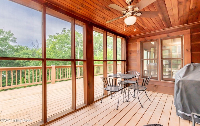 unfurnished sunroom featuring wood ceiling and ceiling fan