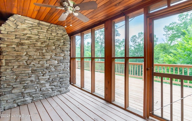 unfurnished sunroom featuring wood ceiling and ceiling fan