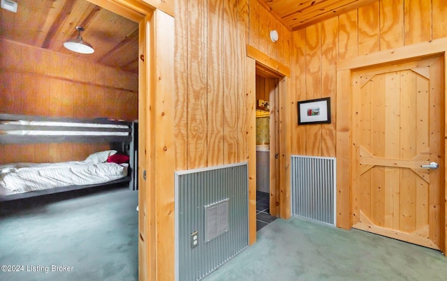 unfurnished bedroom featuring carpet floors, wooden walls, and wooden ceiling