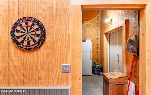 interior space with concrete flooring and wooden walls