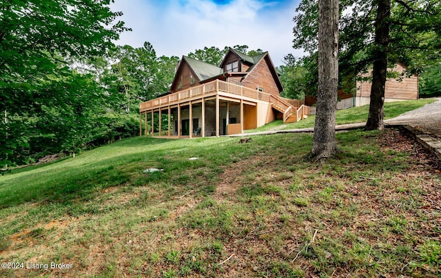 rear view of property featuring a deck and a lawn