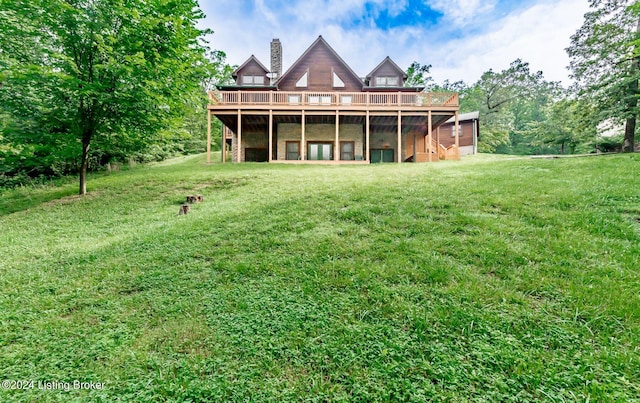 rear view of house featuring a deck and a lawn