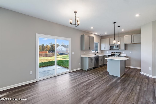 kitchen featuring hanging light fixtures, gray cabinets, stainless steel appliances, and a kitchen island