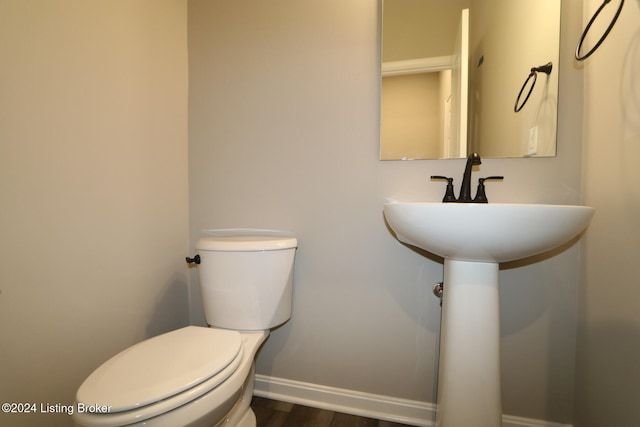 bathroom with toilet and wood-type flooring