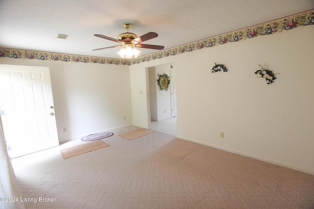 carpeted spare room featuring ceiling fan