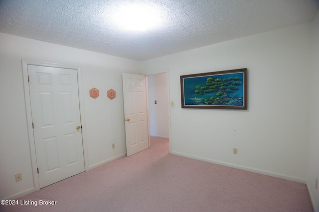 carpeted spare room featuring a textured ceiling