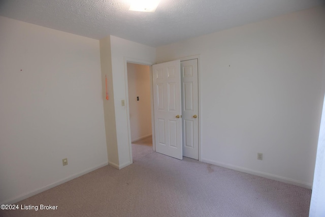 carpeted spare room featuring a textured ceiling