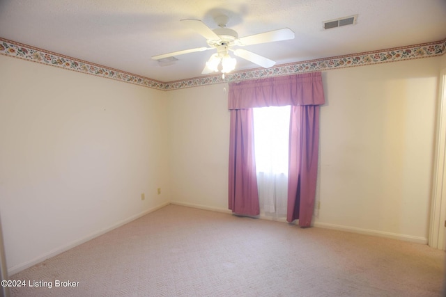 carpeted spare room with ceiling fan