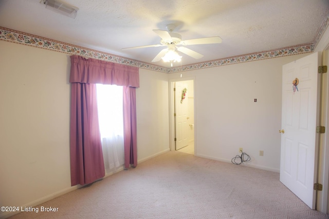 carpeted spare room with a textured ceiling and ceiling fan