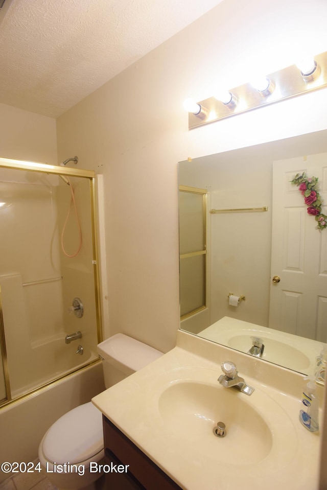 full bathroom with vanity, combined bath / shower with glass door, a textured ceiling, and toilet