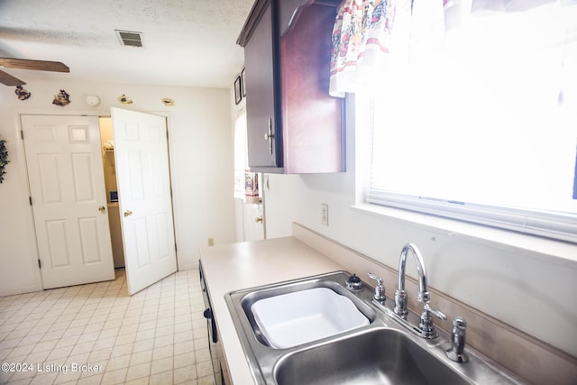 kitchen featuring ceiling fan, sink, and a textured ceiling