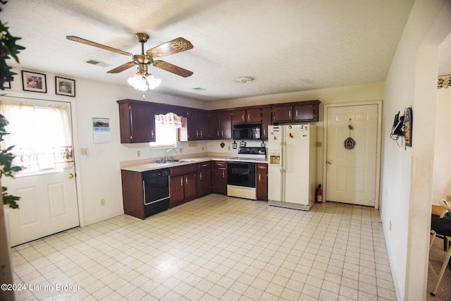 kitchen featuring a textured ceiling, sink, a wealth of natural light, and black appliances