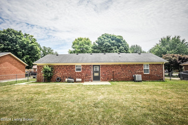 rear view of property with a lawn and cooling unit